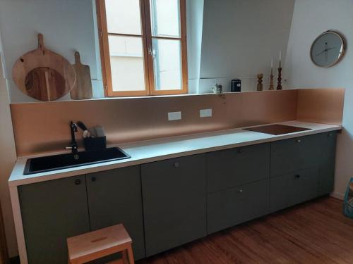 a kitchen with a sink and a counter top at Magnifique Appartement le Nid des Thermes in Bagnères-de-Bigorre