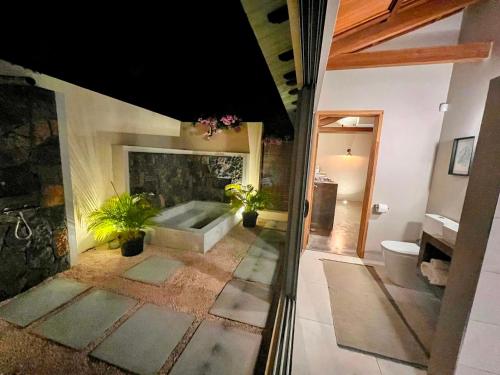 a bathroom with a bath tub and a fireplace at Lakaz Kannell - Vanilla Lodge, secluded outside bath & shower infinity pool in Cap Malheureux