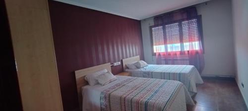 a room with two beds and a window at Nuria's home in Calanda
