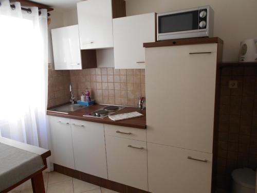 a kitchen with a microwave on top of a refrigerator at Apartment Ana in Zadar