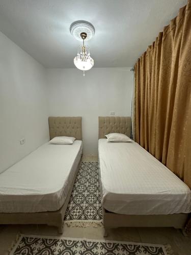 two twin beds in a room with a chandelier at Dar El Rezk in Tunis