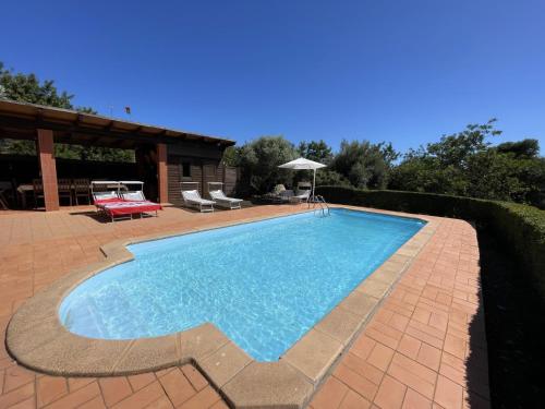 een zwembad in een tuin met een huis bij Villa Horta do Limão 8-10 pessoas a 4 km das praias da Ria Formosa Fuseta in Moncarapacho