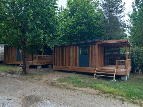 une cabane en bois avec un porche et un arbre dans l'établissement Chalet Zen, à Vaudreuille