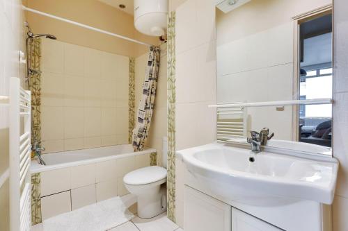 une salle de bain avec un lavabo, des toilettes et une baignoire dans l'établissement le zebre, à Paris