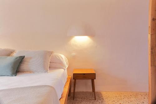 a bedroom with a bed and a table with a lamp at EQUILICUÁ in Agua Amarga