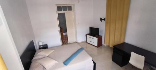 a living room with a white couch and a blue pillow at Casas do Cinema II in Mindelo