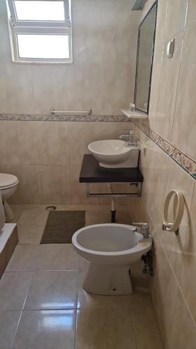 a bathroom with a sink and a toilet and a mirror at Bela Vista in Olhão