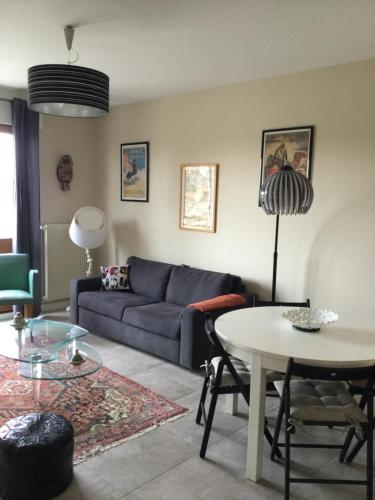 un salon avec un canapé bleu et une table dans l'établissement F2 Résidence Choisnin, à Châtellerault