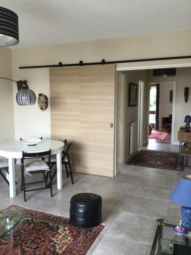 - un salon avec une table blanche et une porte dans l'établissement F2 Résidence Choisnin, à Châtellerault