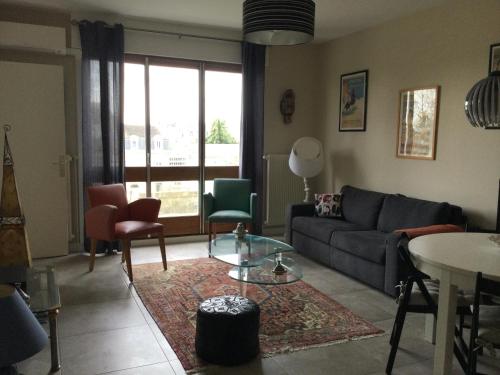 un salon avec un canapé, des chaises et une table dans l'établissement F2 Résidence Choisnin, à Châtellerault