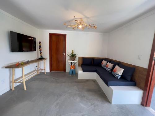 a living room with a blue couch and a television at Morada Santo Antônio in Piranhas