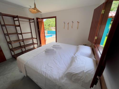 a bedroom with a white bed with a view of a pool at Morada Santo Antônio in Piranhas