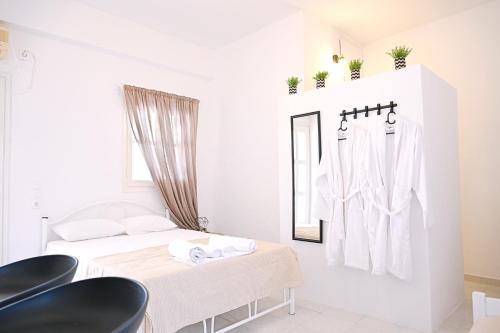 a white room with a bed and a mirror at Panorama View Kanala in Kithnos