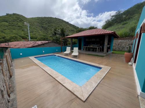 a swimming pool with chairs and a gazebo at Morada Santo Antônio in Piranhas