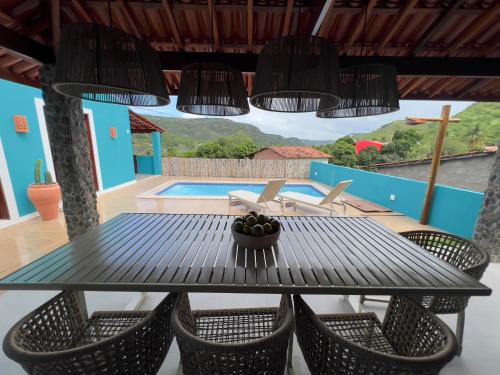 a dining table and chairs with a view of a pool at Morada Santo Antônio in Piranhas