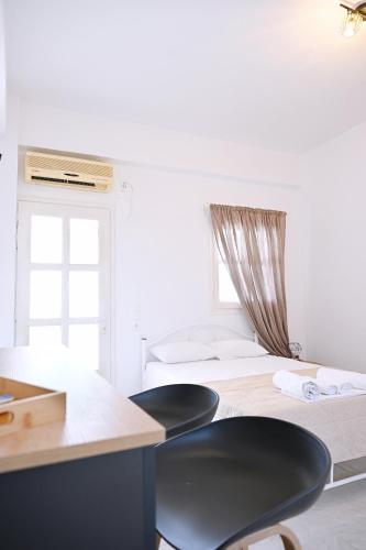 a room with two beds and a desk and chairs at Panorama View Kanala in Kithnos