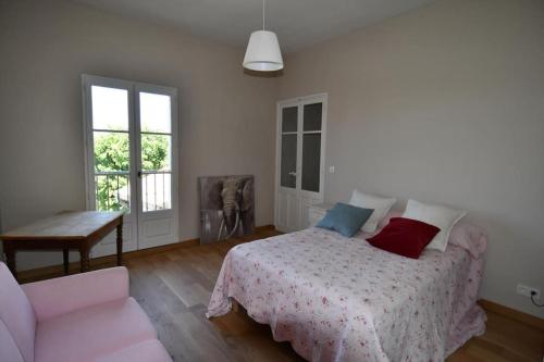 une chambre avec un lit, un canapé et une fenêtre dans l'établissement Charmante Maison de Vacances, à Bédoin