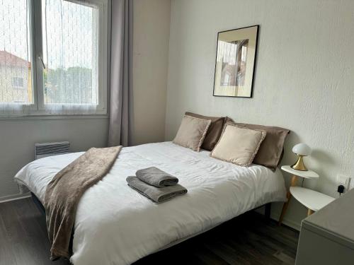 une chambre avec un lit avec deux serviettes dessus dans l'établissement Le Victor Hugo de la Robine, à Narbonne