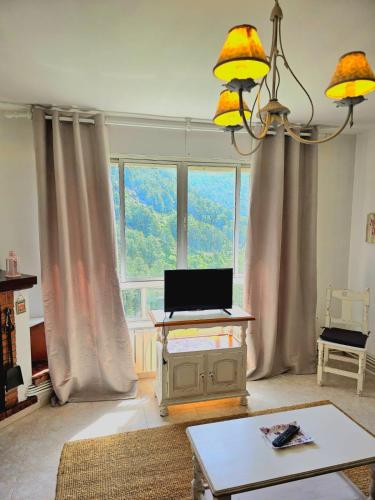 a living room with a laptop on a table in front of a window at ALBAREÍLLA by #cherrygredos in El Arenal