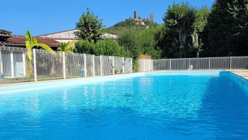 a large blue swimming pool next to a fence at Camping Le Soulhol in Saint-Céré