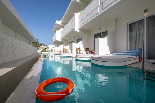 a swimming pool with a red raft in the water at Patricia Suites in Faliraki