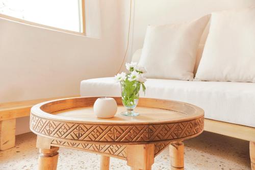a living room with a coffee table with a vase of flowers at EQUILICUÁ in Agua Amarga