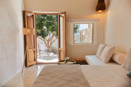a room with a bed and a couch and a window at EQUILICUÁ in Agua Amarga