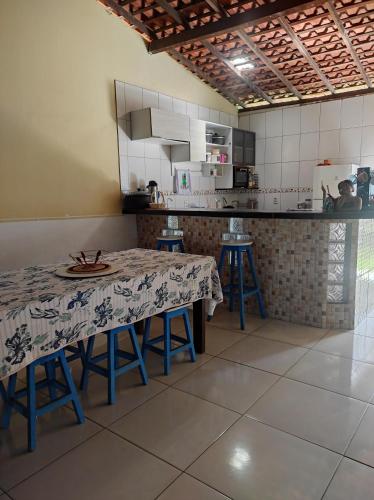 a kitchen with a table and stools in it at Casa Azul in Barreirinhas