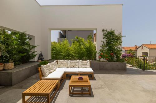 a patio with couches and a table and benches at Zen House in Zadar