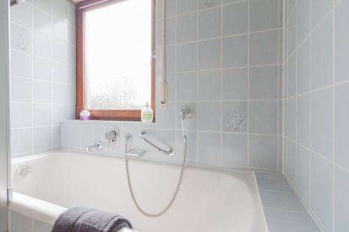 a bathroom with a bath tub with a shower at nJoy! Modern & Chic - Stuttgart Messe - perfekt für work & travel in Leinfelden-Echterdingen