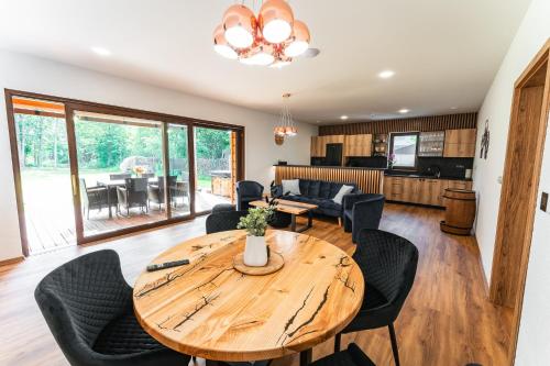 a dining room and living room with a wooden table and chairs at Luxapart Golf Ostravice in Ostravice
