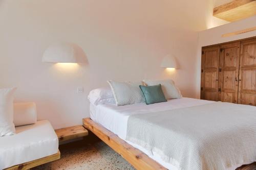 a bedroom with a white bed and a chair at EQUILICUÁ in Agua Amarga