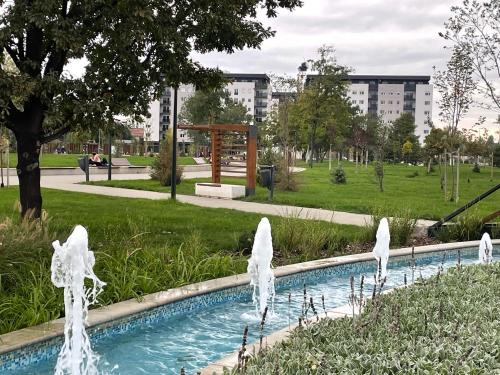 a swimming pool in a park with water fountain at Apartment Park in Novi Sad