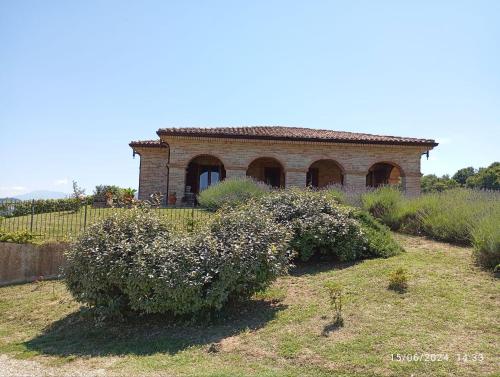 an old brick house with bushes in front of it at Villa Liliana, Exclusive Property in Monte Rinaldo