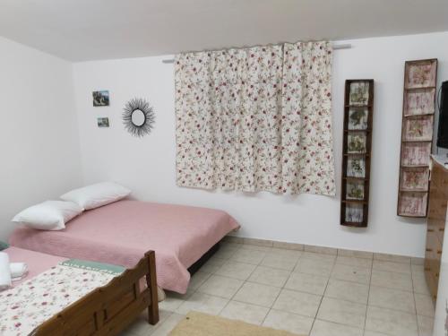 a bedroom with a bed and a window with a curtain at Mountain Top Eleochori Βουνοκορφή in Elaiokhórion