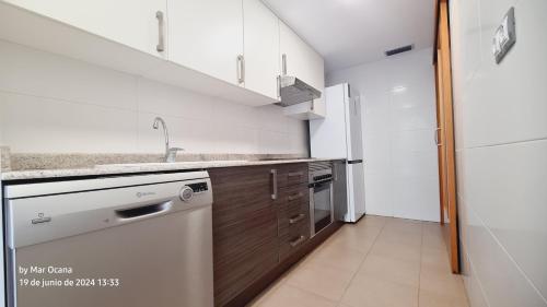 Una cocina blanca con fregadero y lavavajillas. en Alcossebre village 2, en Alcossebre