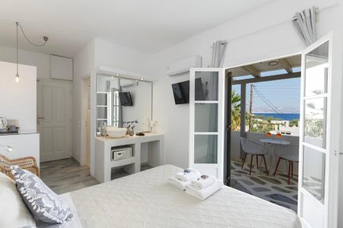 a bedroom with a bed and a kitchen with a table at Margarita Studios Ambelas in Ambelas