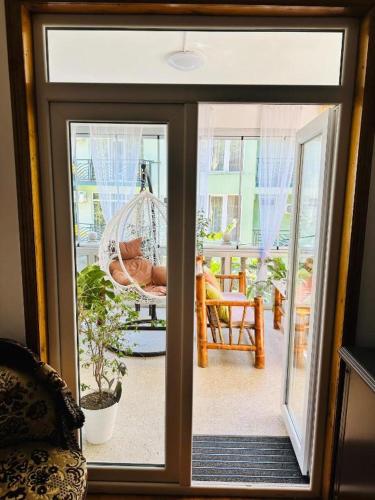 a view of a patio with a hammock through a window at Karakum Villa in Ureki