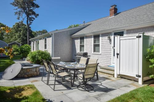 a patio with a table and chairs in a yard at Walk to Earle Rd Beach Incredible Patio in Harwich
