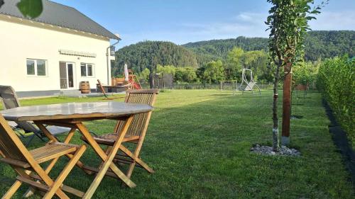 a wooden table and chairs in a yard with a tree at DOM HILLS Bucovina in Gura Humorului