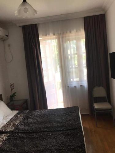 a bedroom with a bed and a window and a chair at Karakum Villa in Ureki