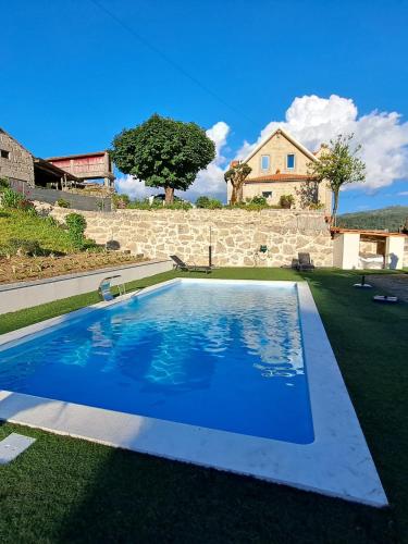 a swimming pool in the yard of a house at Quinta do Bairro in Vieira do Minho