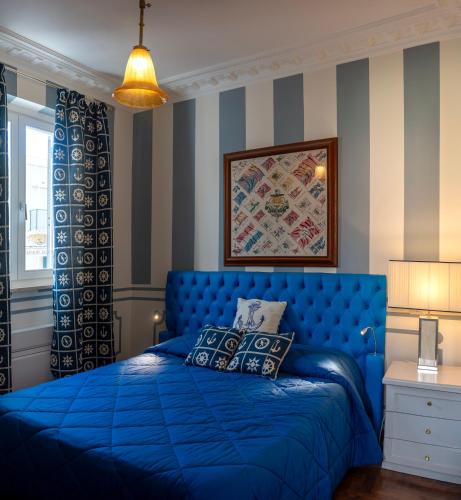 a blue bed in a room with striped walls at Regal House Anzio Terrazzo in Anzio