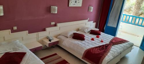 a bedroom with a bed with a red wall at Dar Salem in Djerba