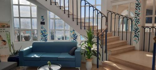 a living room with a blue couch and stairs at Dar Salem in Djerba