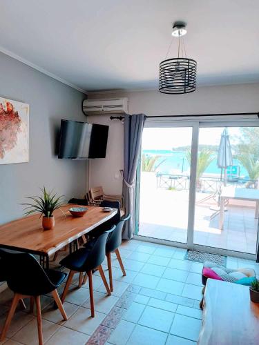 a dining room with a table and chairs and a patio at Hermione Horizon in Ermioni