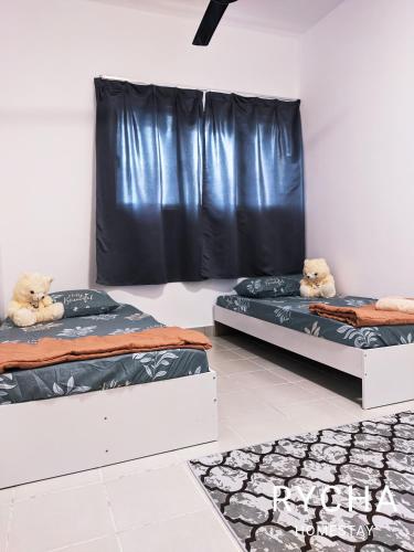 two beds in a room with two teddy bears on them at Rycha Homestay A famosa near Waterpark in Kampong Pulau Sebang