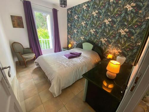 une chambre avec un lit avec un papier peint fleuri dans l'établissement Villa Le Lébérou, à Sarlat-la-Canéda