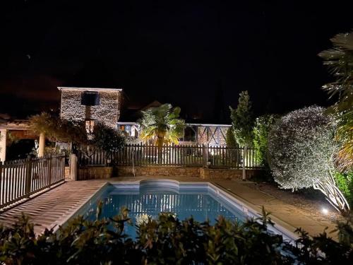 une piscine devant une maison la nuit dans l'établissement Villa Le Lébérou, à Sarlat-la-Canéda