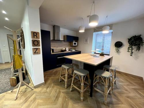- une cuisine avec une table et des tabourets en bois dans l'établissement Les deux maisons - Roz - Appartement Gérardmer vue pistes proche lac, à Gérardmer